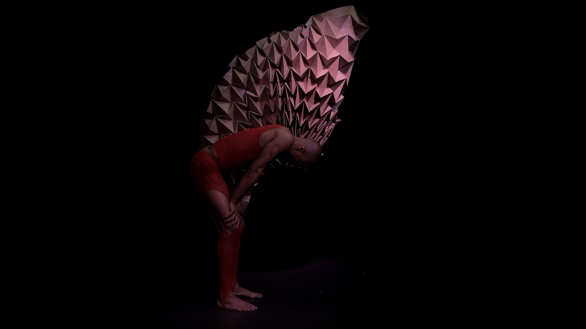 Shamel Pitts alone, bent over, breathing, in front of the sculpture.