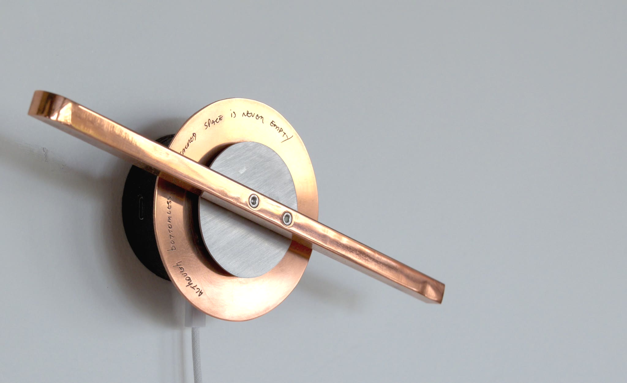 Close view of an Orbital Witness: the engraved copper lid and the pointer crossing it.
